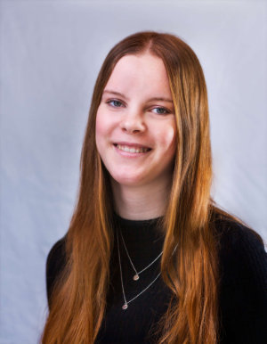 Bewerbungsfotos einer Frau mit langen Haaren, schwarzen Oberteil vor einem weißen Hintergrund.