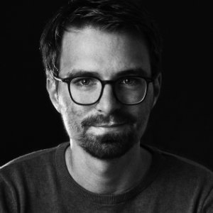 Schwarz-weißes, kontrastreiches Portraits eines Mannes.