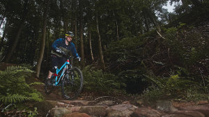 Mann fährt auf dem Mountainbike auf einem steinigen Weg durch den Wald in Miltenberg.